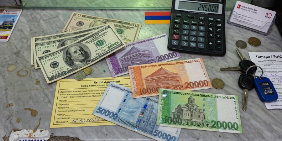 US-Dollar-Scheine und armenische Dram-Banknoten auf einem Mietschalter in Eriwan