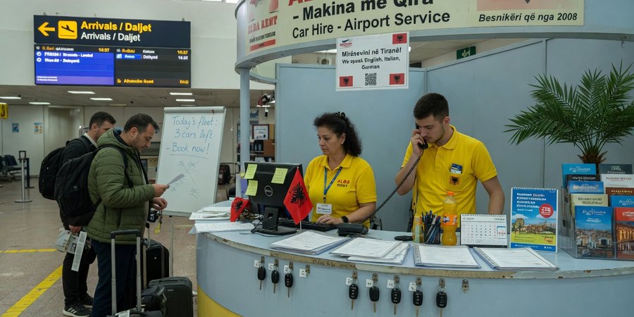 Mietwagenübergabe in der Ankunftshalle des Tirana International Airport am späten Abend