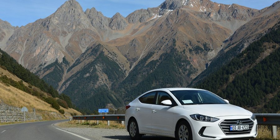Mietwagen vor Kaukasus-Bergkulisse in Georgien