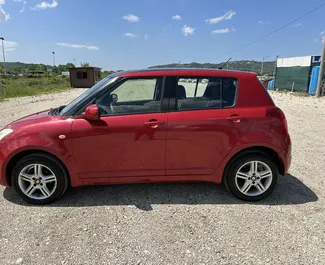 Frontansicht eines Mietwagens Suzuki Swift am Flughafen von Tirana, Albanien ✓ Auto Nr.13186. ✓ Schaltgetriebe TM ✓ 0 Bewertungen.