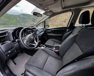 Innenraum von Honda Fit zur Miete in Georgien. Ein großartiges 5-Sitzer Fahrzeug mit Automatisch Getriebe.