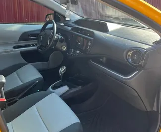 Innenraum von Toyota Prius C zur Miete in Georgien. Ein großartiges 5-Sitzer Fahrzeug mit Automatisch Getriebe.