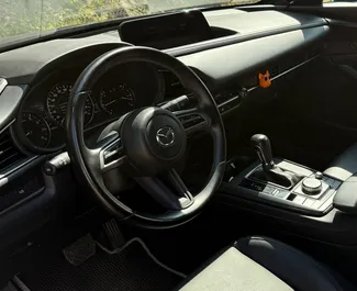 Innenraum von Mazda CX-30 zur Miete in Georgien. Ein großartiges 5-Sitzer Fahrzeug mit Automatisch Getriebe.