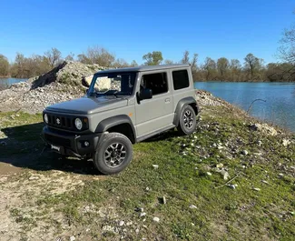Frontansicht eines Mietwagens Suzuki Jimny am Flughafen Podgorica, Montenegro ✓ Auto Nr.15693. ✓ Automatisch TM ✓ 0 Bewertungen.