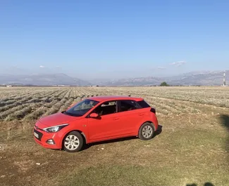 Frontansicht eines Mietwagens Hyundai i20 am Flughafen Podgorica, Montenegro ✓ Auto Nr.15721. ✓ Automatisch TM ✓ 0 Bewertungen.