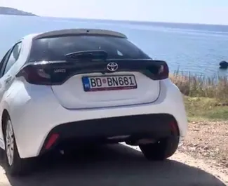 Frontansicht eines Mietwagens Toyota Yaris am Flughafen Podgorica, Montenegro ✓ Auto Nr.16209. ✓ Automatisch TM ✓ 0 Bewertungen.