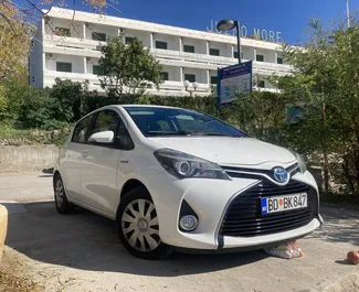 Frontansicht eines Mietwagens Toyota Yaris am Flughafen Podgorica, Montenegro ✓ Auto Nr.16210. ✓ Automatisch TM ✓ 0 Bewertungen.